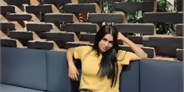 Beautiful picture of Manuela Escobar sitting on sofa wearing yellow shirt