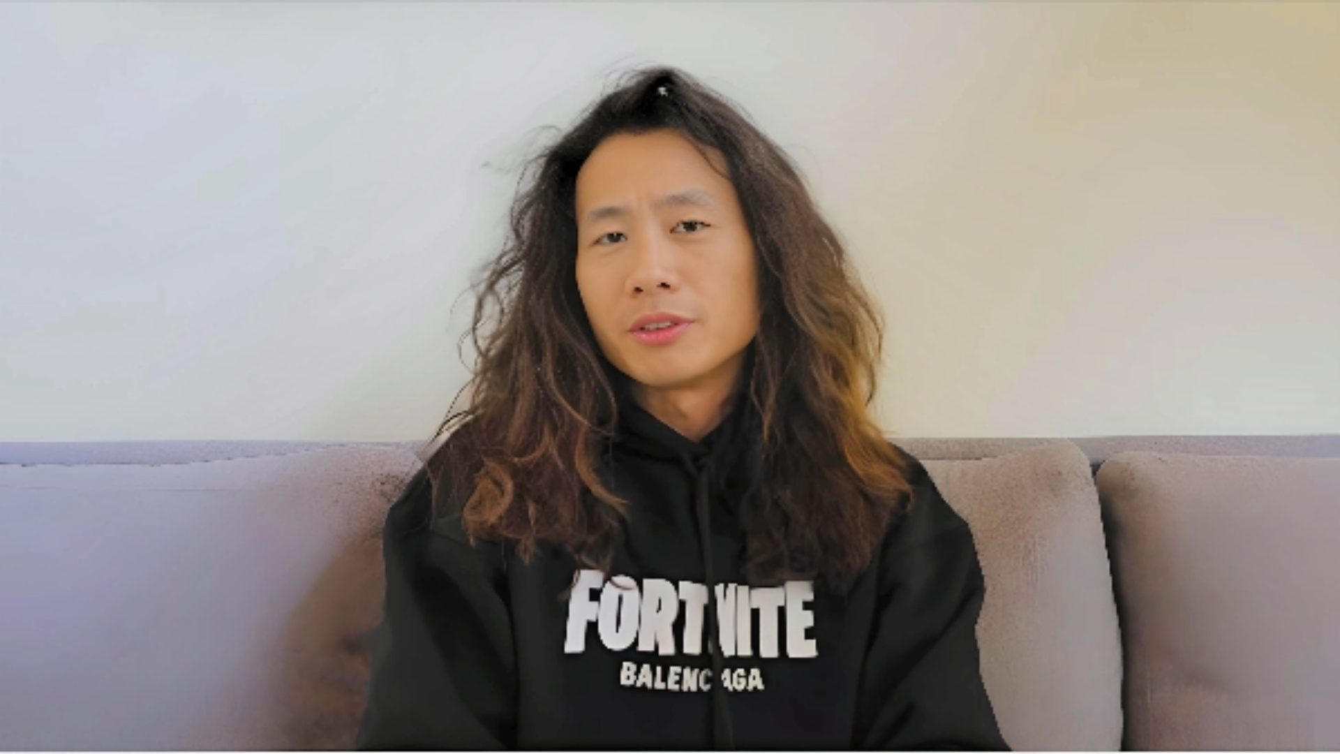 Justin Kan Net Worth 2023: How Rich is Twitch & Atrium Founder? wearing black hoodie sitting on sofa