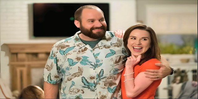 Beautiful picture of Tom Segura (wearing grey butterfly shirt) and his wife Christina Pazsitzky( wearing orange top), depicting their strong bond.